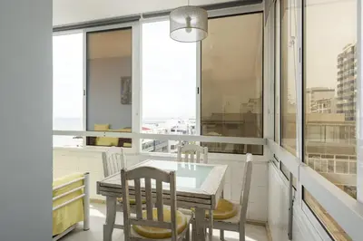a dining room with a table and chairs and windows at Horizonte - Sea view by HD PROPERTIES in Quarteira