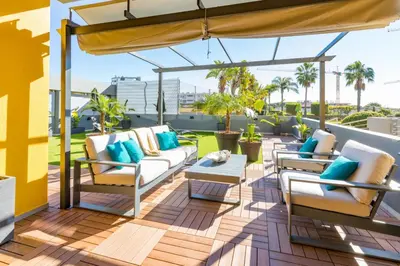 a patio with couches and chairs on a deck at Stunning Exclusive Parque Atlântico in Quarteira