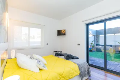 a bedroom with a yellow bed and a large window at Stunning Exclusive Parque Atlântico in Quarteira
