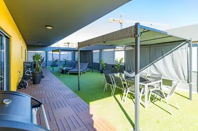 a patio with a table and chairs on a roof at Stunning Exclusive Parque Atlântico in Quarteira