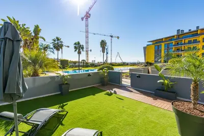 a patio with a lawn and a swimming pool at Stunning Exclusive Parque Atlântico in Quarteira