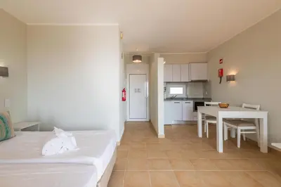 a room with a bed and a table and a kitchen at Albufeira Jardim Studio with Sea View - Free Wi-Fi - Pool in Albufeira