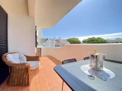 a table and chairs on a balcony with a view of the ocean at Vilamoura Twins 2 With Pool by Homing in Vilamoura