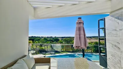 a view of a pool from a living room with an umbrella at Lake24 CD256- CleverDetails, 3 bedroom apartment, sleeps 6, near to Falesia Beach and the Marina in Vilamoura