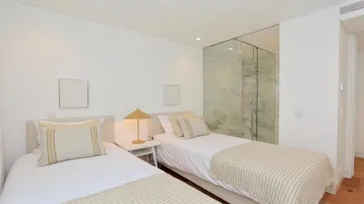 two beds in a white room with a window at Lake24 CD256- CleverDetails, 3 bedroom apartment, sleeps 6, near to Falesia Beach and the Marina in Vilamoura