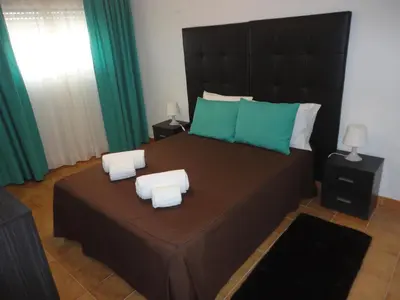 a bedroom with a large bed with two pillows at Original Apartments in Albufeira