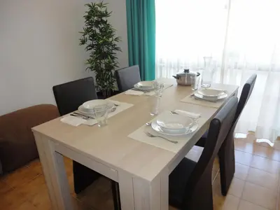 a dining room table with chairs and a white table set with dishes at Original Apartments in Albufeira
