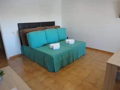 a blue couch in a room with a table at Original Apartments in Albufeira