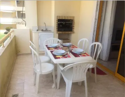 a kitchen and living room with a table and a living room at T2 Vila Atlântida Praia Vilamoura in Quarteira