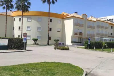 a kitchen with a washing machine and a table with chairs at T2 Vila Atlântida Praia Vilamoura in Quarteira