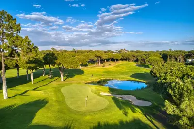an overhead view of a golf course with a pond at T2 Vila Atlântida Praia Vilamoura in Quarteira