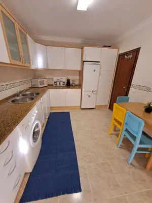 a bedroom with a large bed and a table at T2 Vila Atlântida Praia Vilamoura in Quarteira