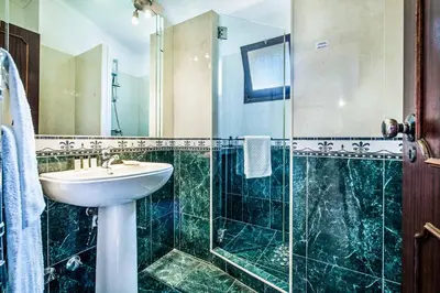 a bathroom with a sink and a glass shower at Villa Toad Hall in Galé