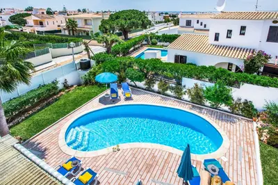 an overhead view of a swimming pool with chairs and umbrellas at Villa Toad Hall in Galé
