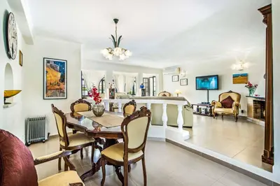a dining room and living room with a table and chairs at Villa Toad Hall in Galé
