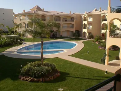 a large building with a swimming pool in a yard at Praia Village AG in Vilamoura