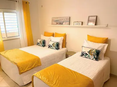 two beds in a room with yellow and white at Praia Village AG in Vilamoura