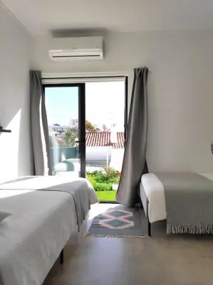 a bedroom with a bed and a large window at Airy 3br, AC, Garden, 2min Strip, 8min Oura Beach in Albufeira