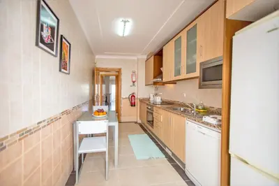 a kitchen with wooden cabinets and a white refrigerator at Villa Albufeira by Atlantic Places in Albufeira