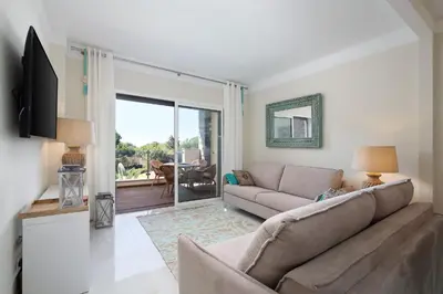 a living room with a couch and a sliding glass door at Apartament Belharucas, 400 meters from beach in Albufeira
