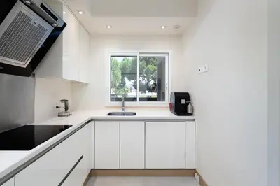 a white kitchen with a sink and a window at Apartament Belharucas, 400 meters from beach in Albufeira