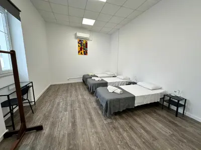 a room with three beds and a painting on the wall at Albergaria Formosa in Faro