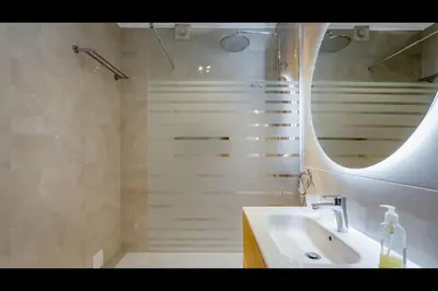 a bathroom with a sink and a shower with a mirror at Ocean Oasis by LovelyStay in Albufeira