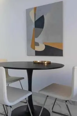 a black table with two white chairs and a painting at Downtown Art Flat in Albufeira