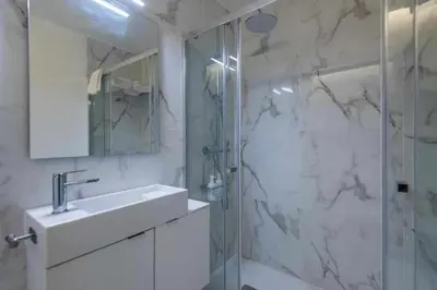 a white bathroom with a sink and a shower at Downtown Art Flat in Albufeira