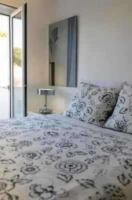 a bedroom with a bed and a lamp on a table at Downtown Art Flat in Albufeira