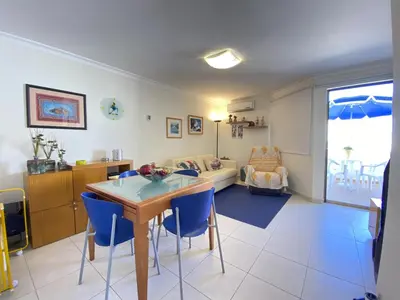 a living room with a table and blue chairs at Vilamoura Central 7 With Pool by Homing in Vilamoura