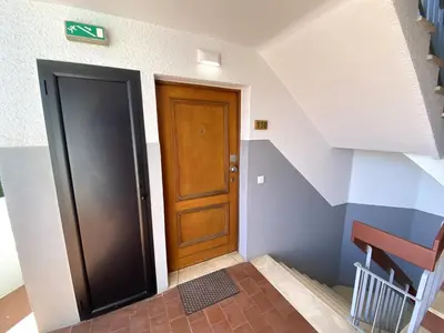 an empty hallway with a wooden door and stairs at Vilamoura Central 7 With Pool by Homing in Vilamoura