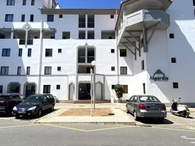 a white building with cars parked in a parking lot at Vilamoura Central 7 With Pool by Homing in Vilamoura