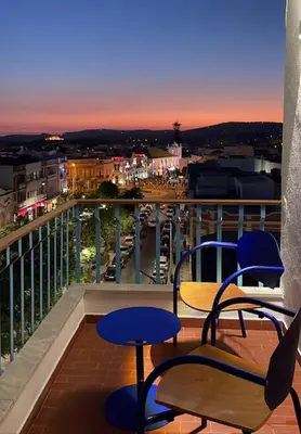 a balcony with two blue chairs and a view of a city at Loulé Old Town Apartment in Loulé
