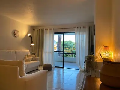 a living room with a white couch and a sliding glass door at Solar Dos Pinheiros in Quarteira