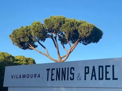 a sign with a tree in the background at Solar Dos Pinheiros in Quarteira