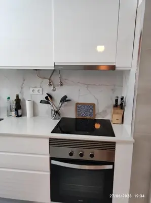 a stove top oven in a kitchen with white cabinets at The Retreat - O Retiro Algarvio in Faro