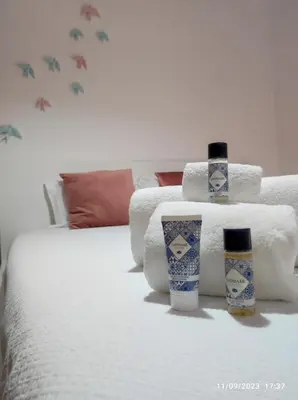 a bed with towels and two vases on it at The Retreat - O Retiro Algarvio in Faro
