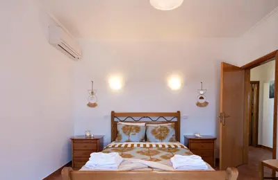 a bedroom with a bed and two dressers and lights at Villa Luz Vieira in Albufeira