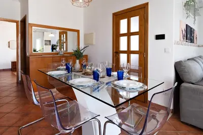 a dining room with a glass table and chairs at Villa Luz Vieira in Albufeira