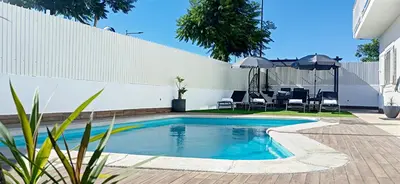 a swimming pool in a backyard with a table and chairs at Villa Luz Vieira in Albufeira