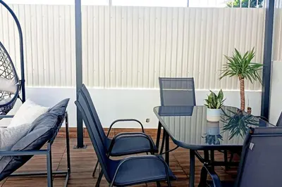 a patio with a table and chairs and a plant at Villa Luz Vieira in Albufeira