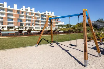 a swing set in a park with a building in the background at The Albufeira Concierge - Prime Lounge Design in Albufeira