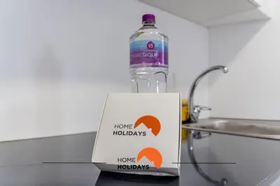 a bottle of water and a sign next to a sink at #163 Dr José Silva 17 by Home Holidays in Albufeira