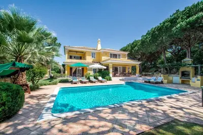 a house with a swimming pool in front of a house at Villa Plaza - beautiful spacious house off roundabout 6 Quinta Do Lago in Quinta do Lago