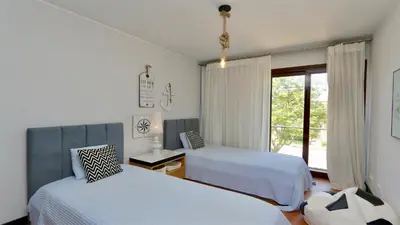 a bedroom with two beds and a window at Vila Mitri, Monte laguna-CleverDetails, 5 bedroom villa, sleeps 8 adults 2 children in Vilamoura