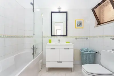 a bathroom with a sink and a tub and a toilet at Host Wise - Fresh Sunny Flat with Pool & Terrace in Olhos de Água