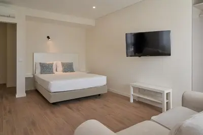 a bedroom with a bed and a flat screen tv at LEGACY SUITES & APARTMENTS ALBUFEIRA AL - No Groups in Albufeira