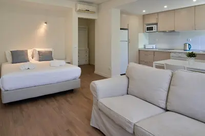 a white bed with two towels on top of it at LEGACY SUITES & APARTMENTS ALBUFEIRA AL - No Groups in Albufeira