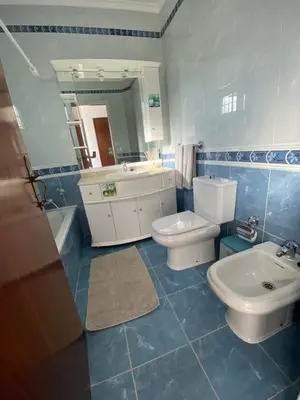 a bathroom with two toilets and a sink and a mirror at Moradia Olival- BBQ, 2 Quartos, Quintal in Albufeira